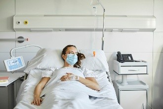 Mujer acostada en una cama de hospital.