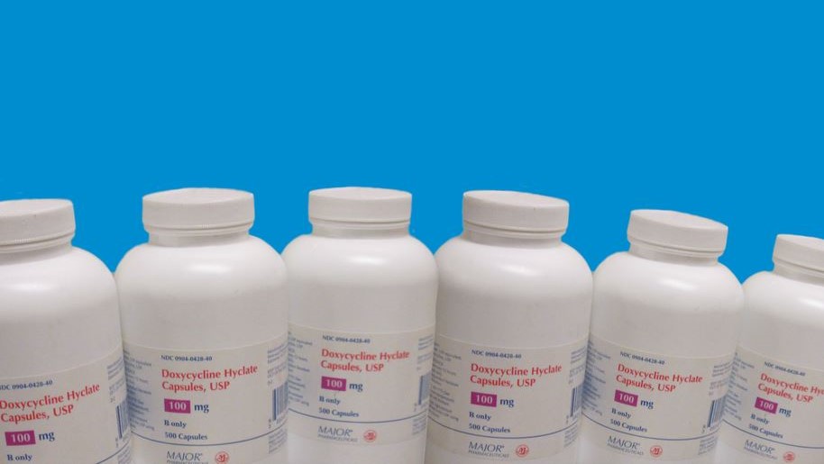 Six doxycycline bottles lined up in a row.