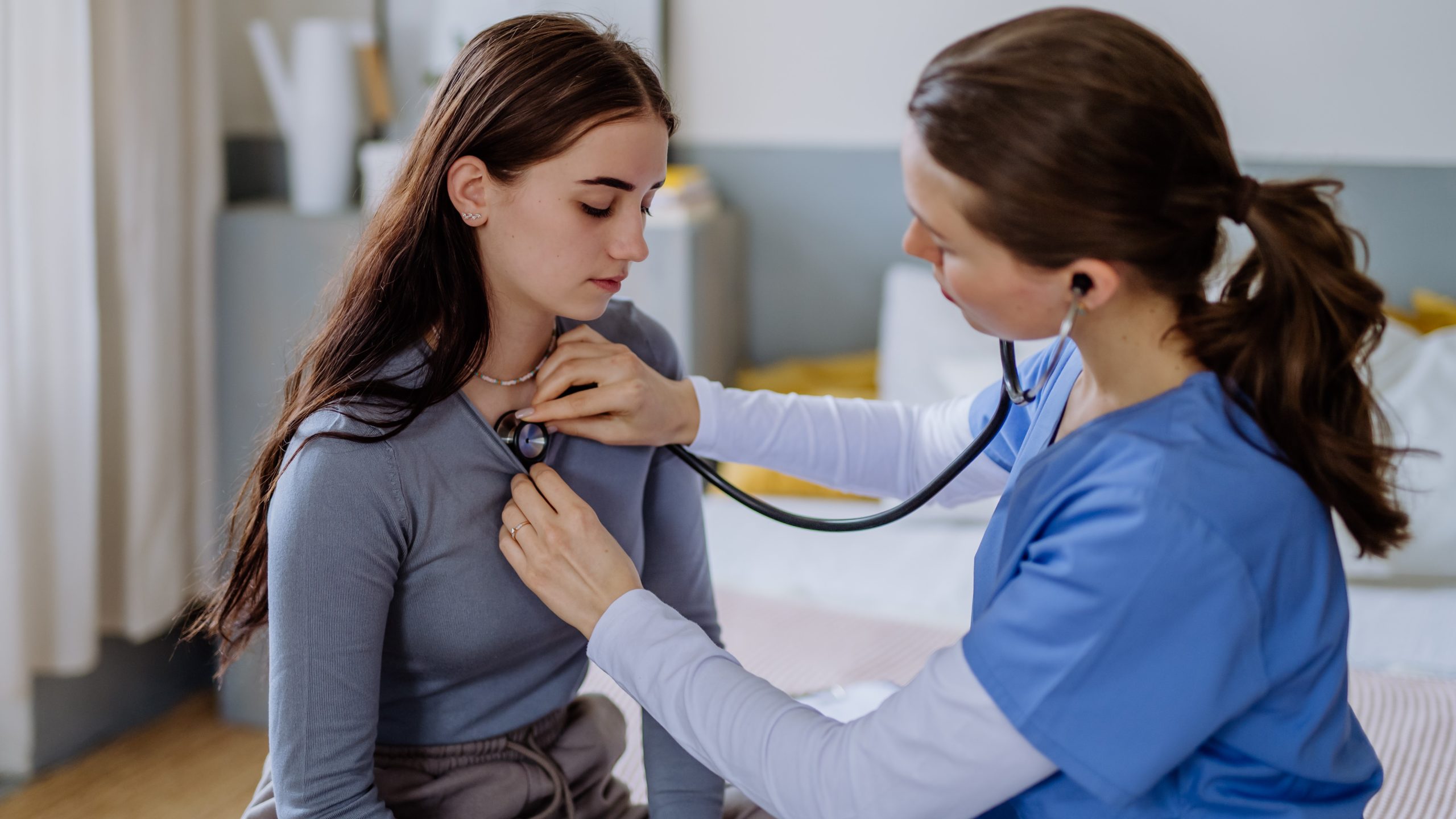 Female doctor examining young female patient.