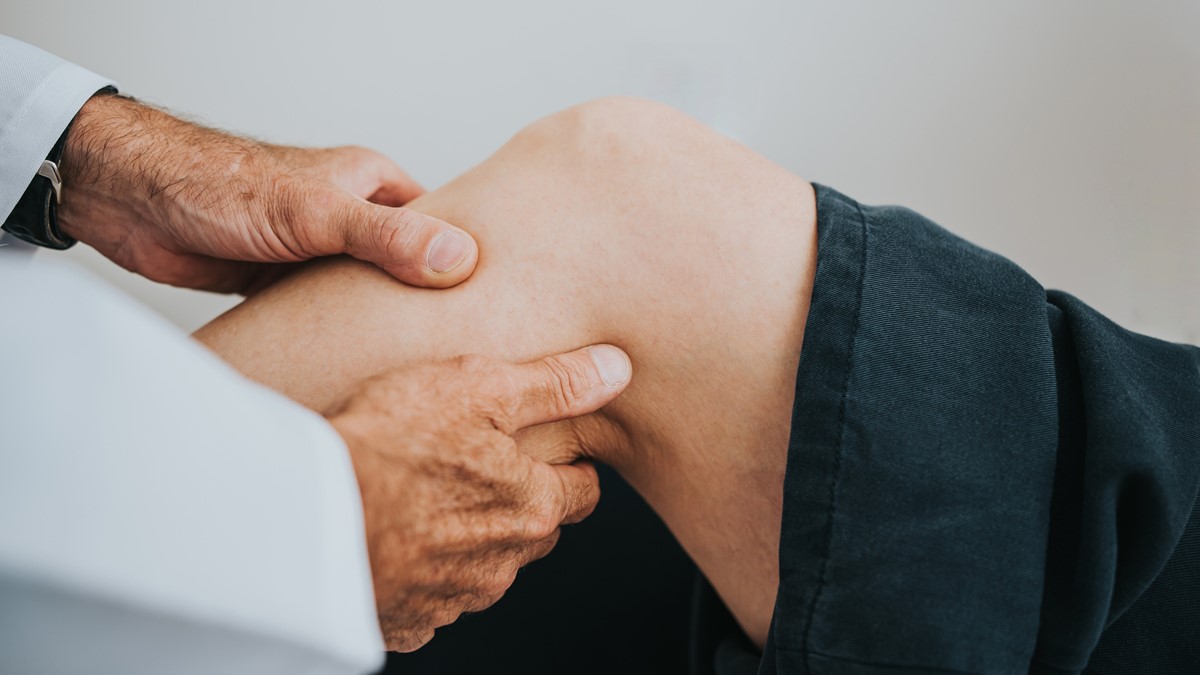 A healthcare provider examines a patient's arthritic knee.