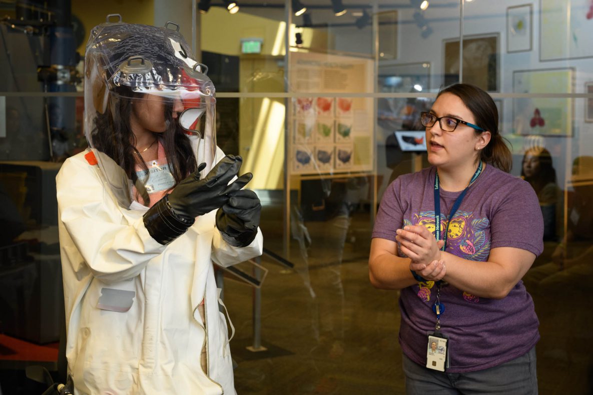 student-trying-lab-suit Student trying on biosafety laboratory suit