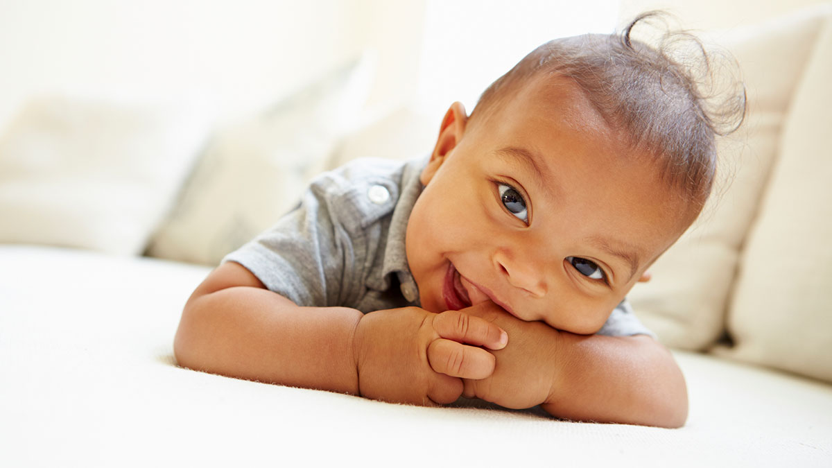 A happy baby lying on his stomach