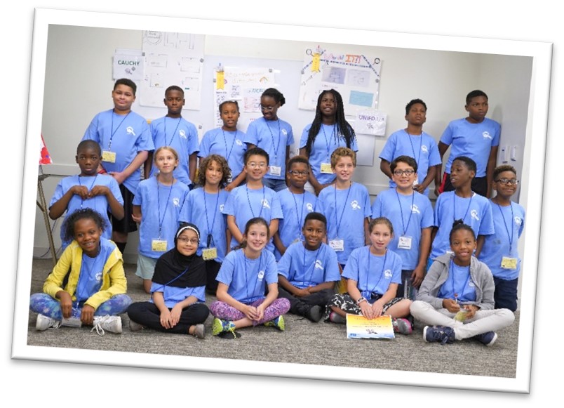 2018 camp group photo showing 20+ campers in matching baby blue shirts.