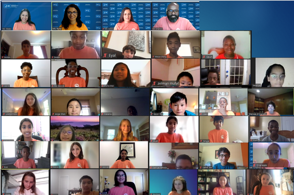 2022 virtual camp group photo. A screenshot showing Zoom windows of campers and staff wearing matching orange shirts.