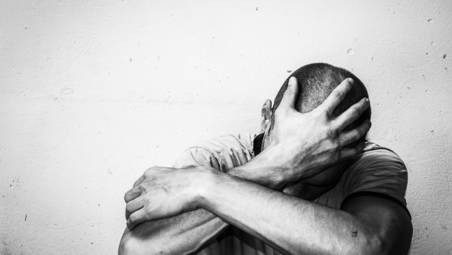 Image of male holding hand on head