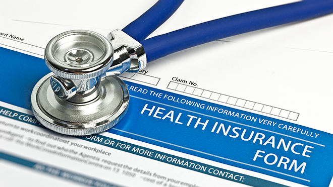 A paper reading health insurance form with a stethoscope placed on top of it.