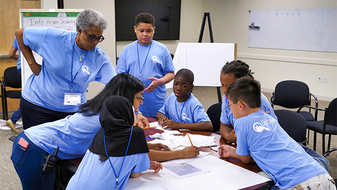 Group of campers and instructor enjoying exploring data and stats.