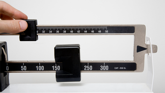 Hand adjusting weight measurements on a scale