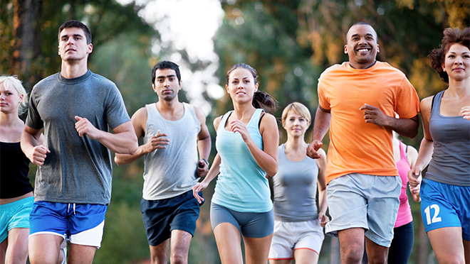 A group of adults, men and women of different ages and ethnicities, running for exercise.