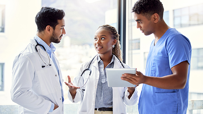 Healthcare providers discussing information on a tablet