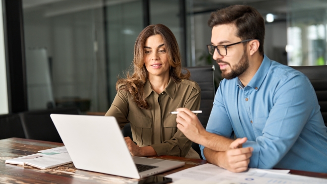 A man and a woman review information on a laptop computer