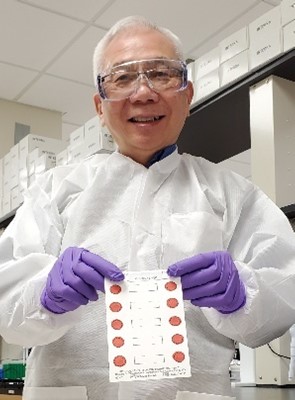 CDC Research Microbiologist Francis Lee holding dried blood spots. CDC Research Microbiologist Francis Lee holding dried blood spots