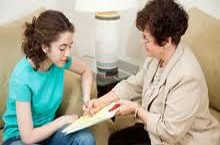 Women reading over notepad with teen