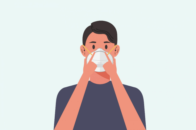 Person pressing down on N95 nose piece.