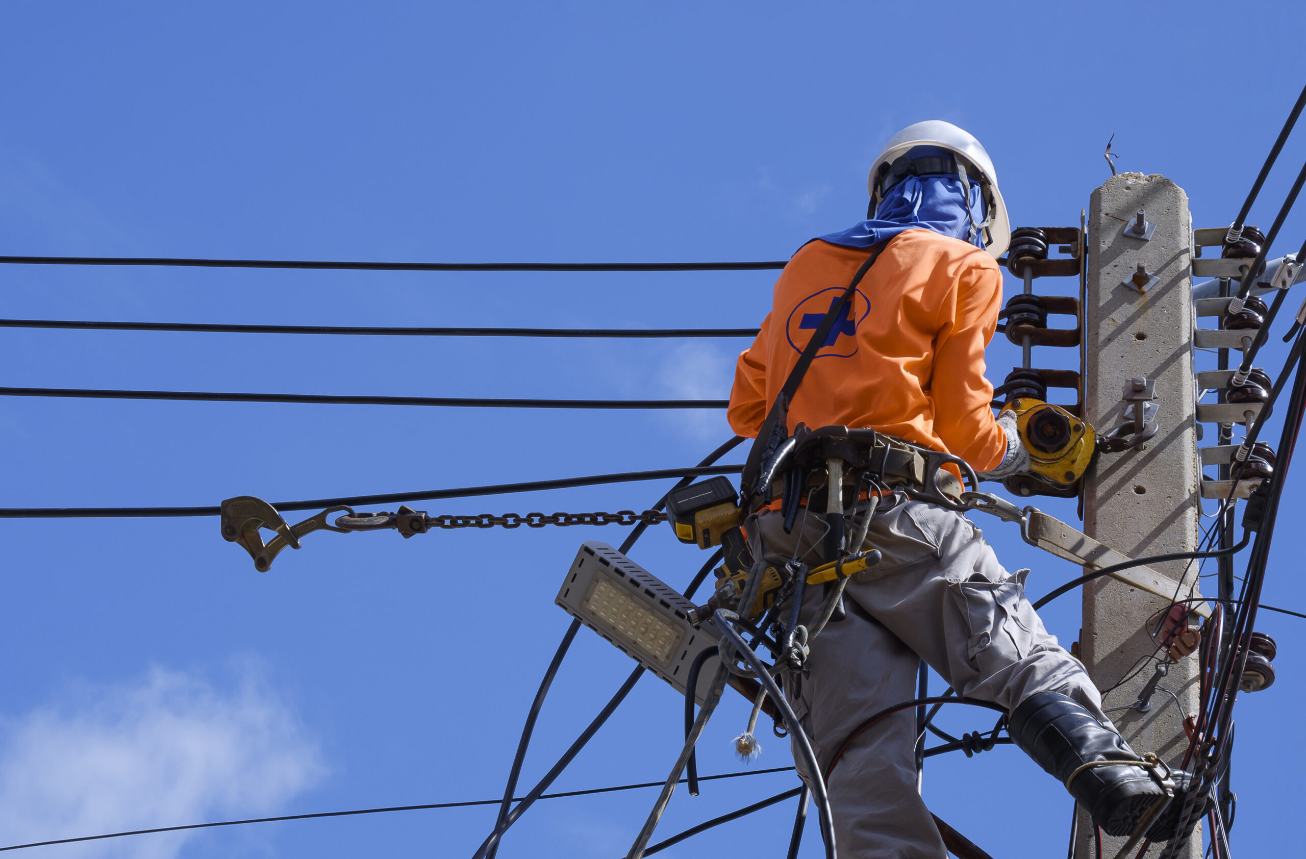 Photo of a lone worker working on elevated power lines