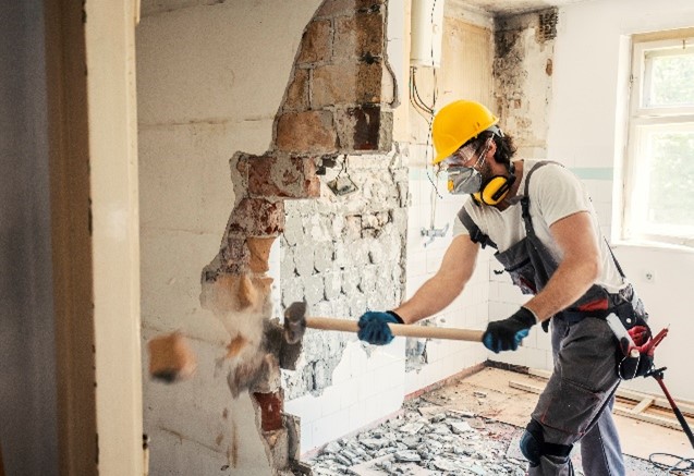 Construction worker doing wall demolition.