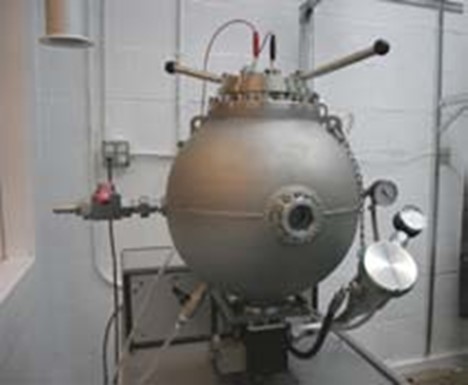 Siwek 20-L explosivity chamber - a round grey apparatus.