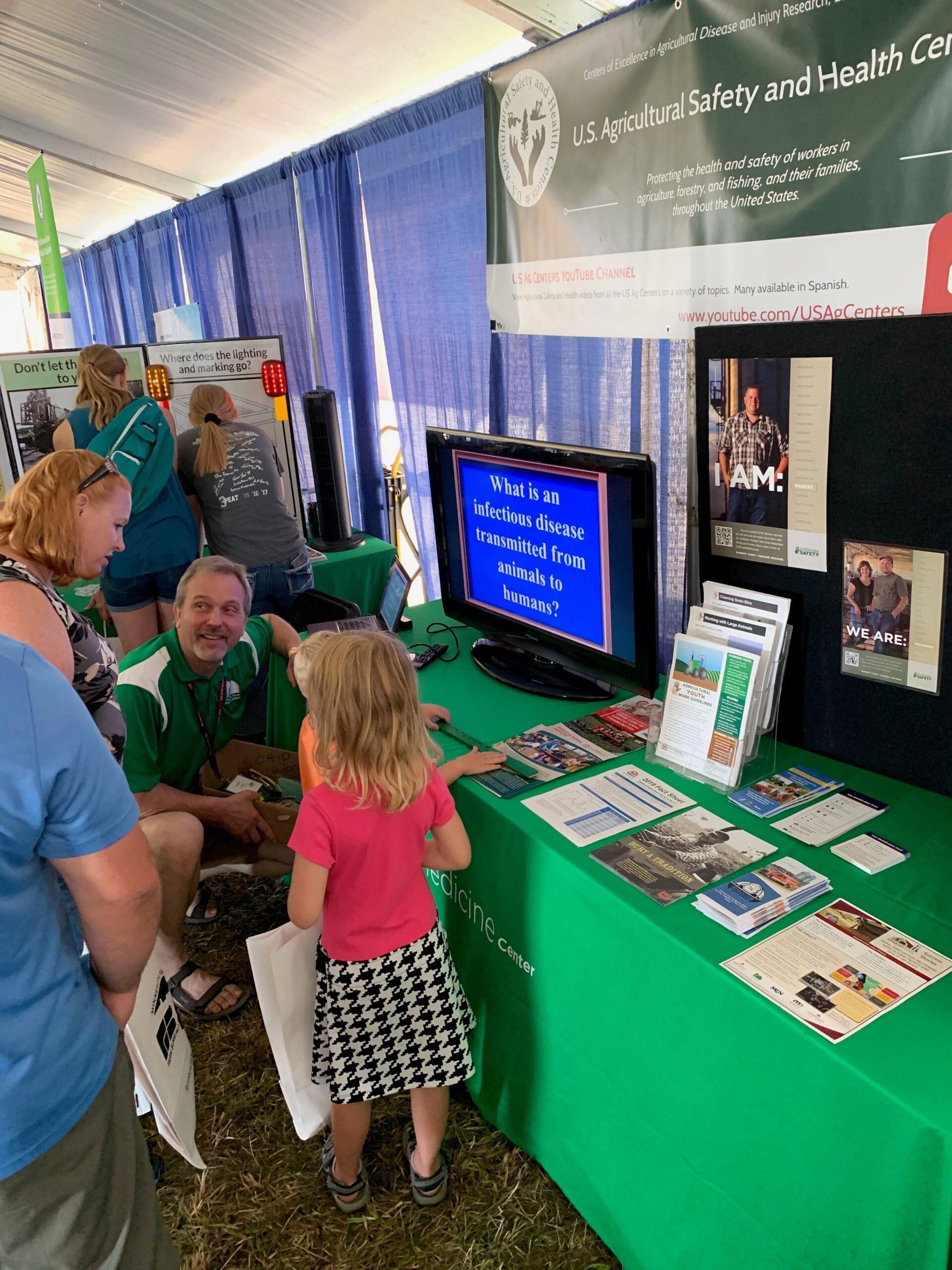 Scott Heiberger, MS, with the National Children’s Center for Rural and Agricultural Health and Safety, talks to a farm family about the Agricultural Youth Work Guidelines.