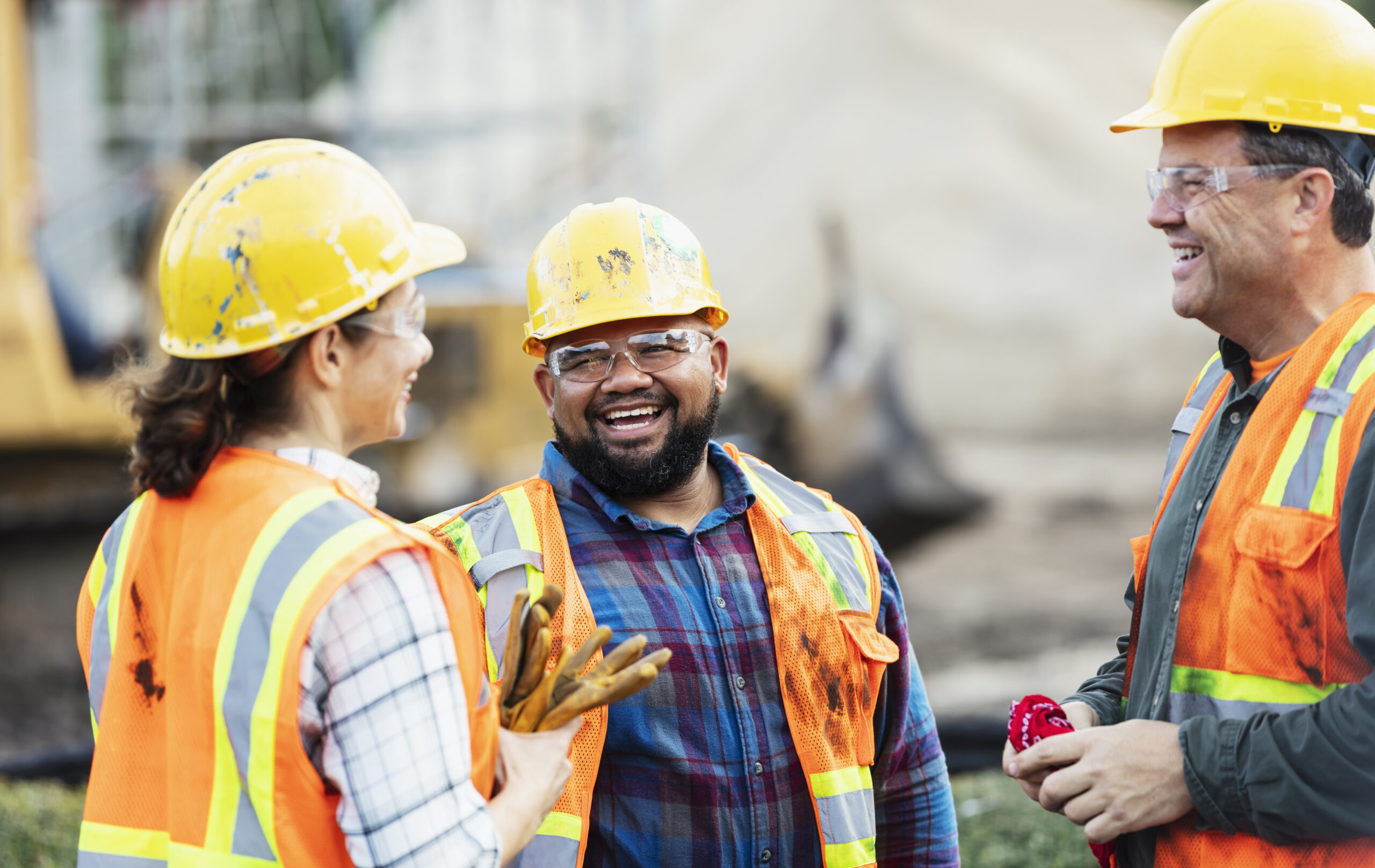 Three construction workers wearing helmets.