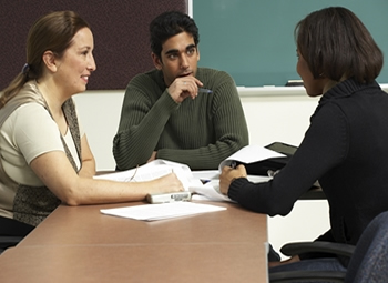 Students conversing around a table.