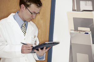 physician looking at a electronic health record on his tablet.