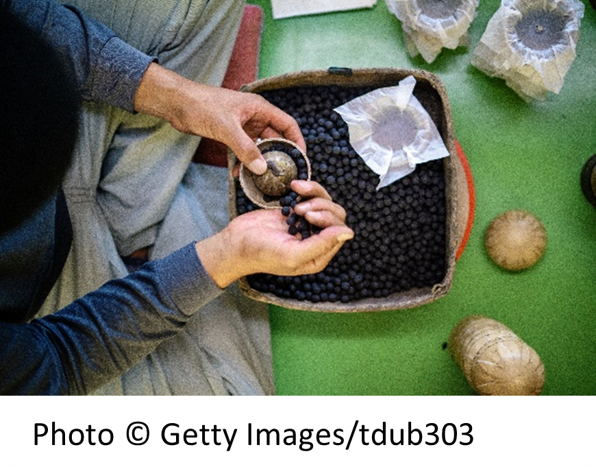 Worker filling fireworks by hand.