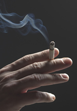 photo of hand holding a lit cigarette.