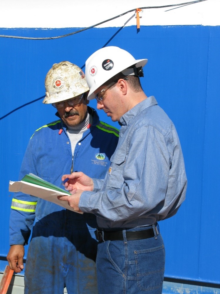 WSD researcher Ryan Hill discusses a safety issue with an oil and gas worker on a rig site in Texas.