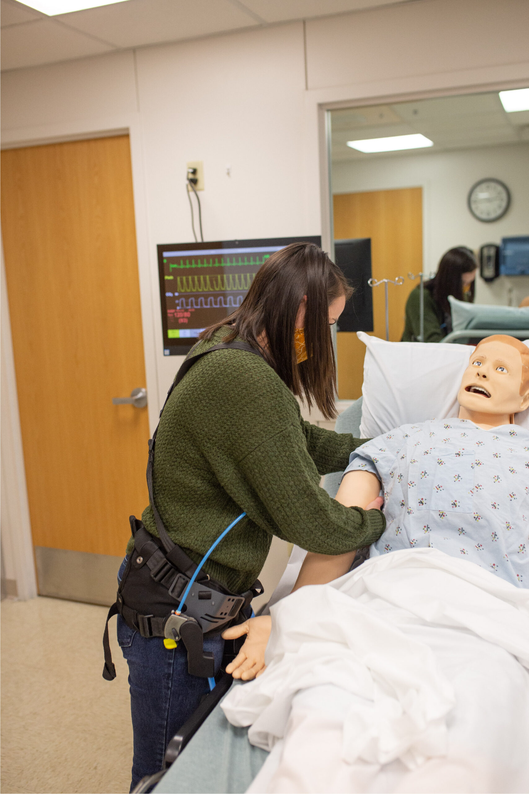 NIOSH Biomedical Engineer tests a passive exoskeleton while handling a patient mannequin