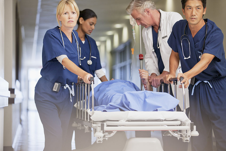 nurses moving a patient on a gurney