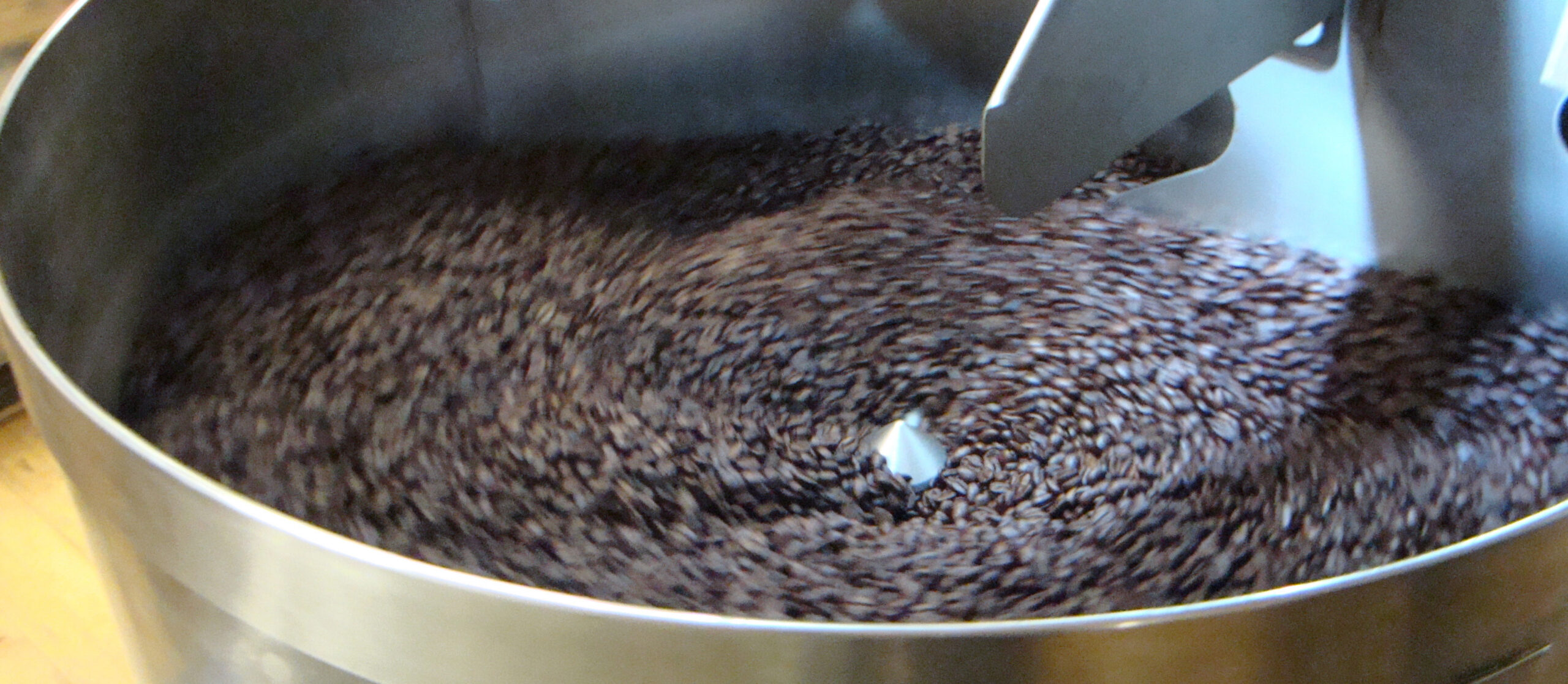 large amount of coffee beans in a roaster, churning