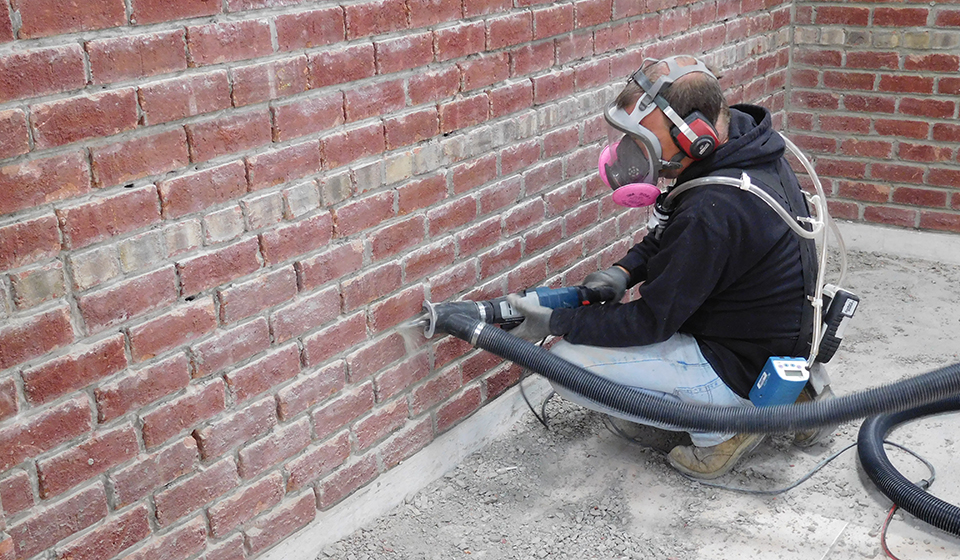 Tuckpointing with dust controls and respirator. Photo from NIOSH