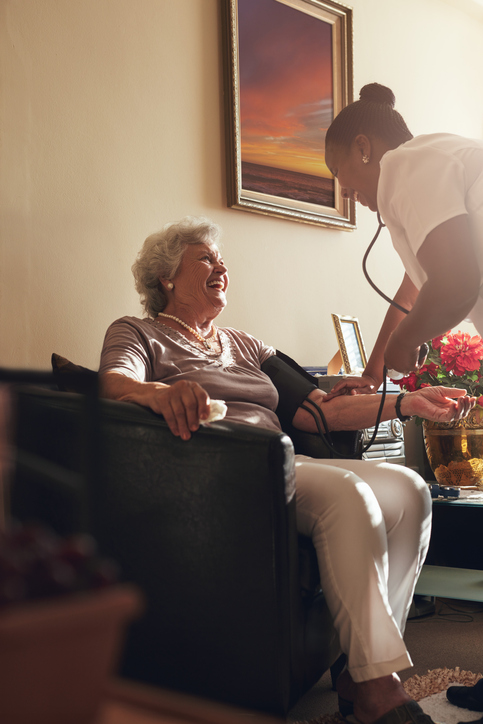 A home healthcare worker taking a patient's blood pressure.