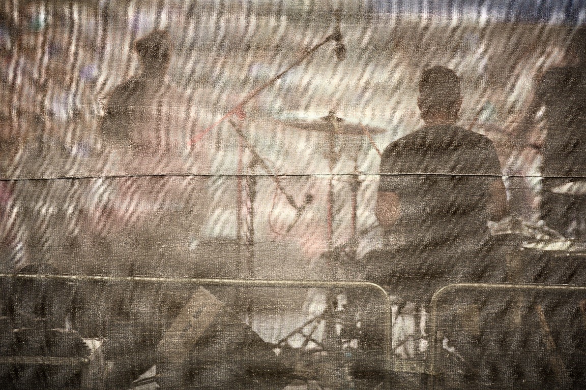 Semi-blurry image of musicians at a concert, photo taken from backstage