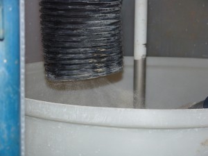 A simple hood capturing powder from a mixing tank in a nanomaterial production facility