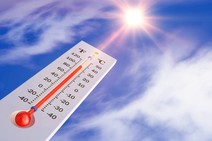 photo with thermometer registering 100 degrees and sunny sky in background.