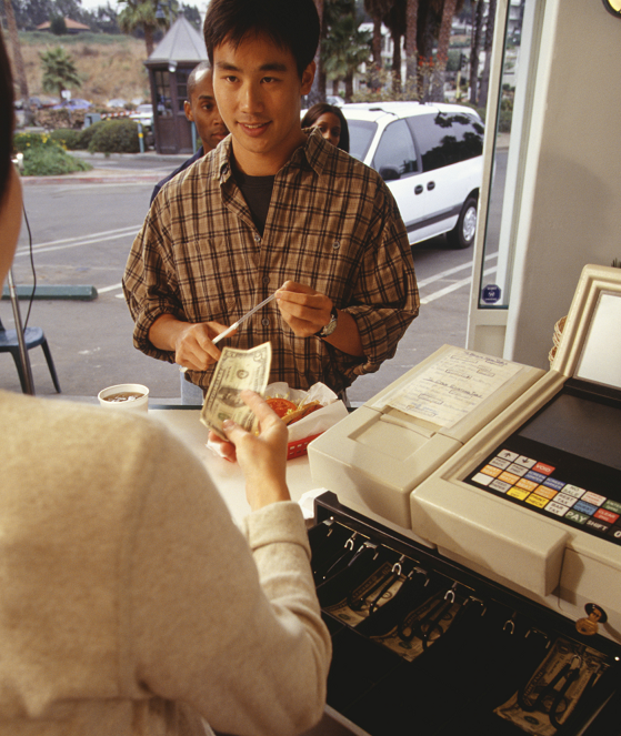 A young man checking out at a convenience store register