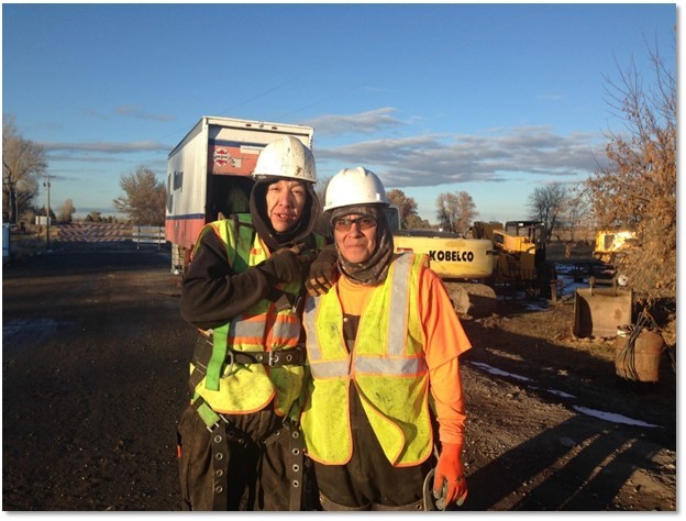 Two construction workers smiling for the camera