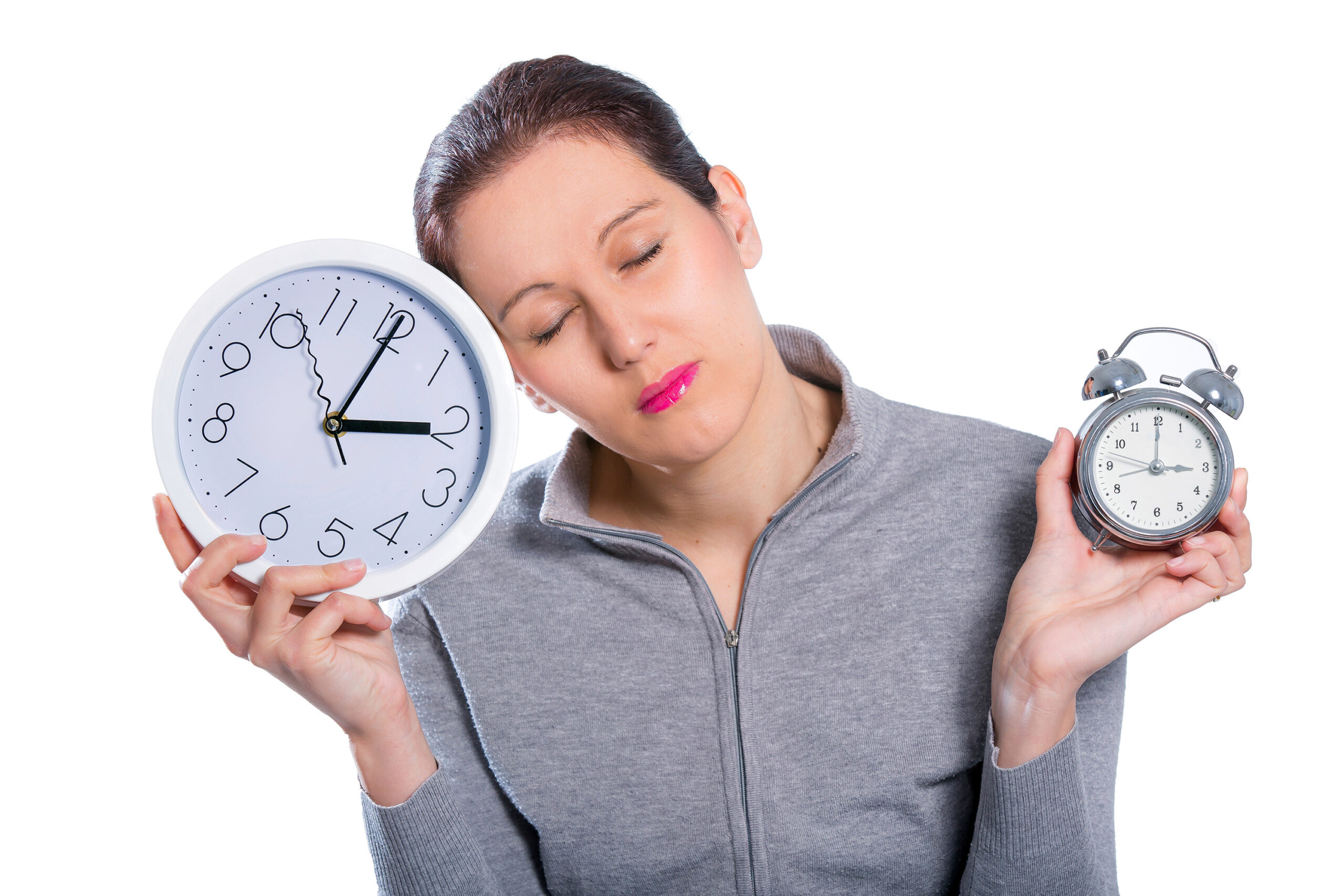Woman looking sleepy holding two clocks