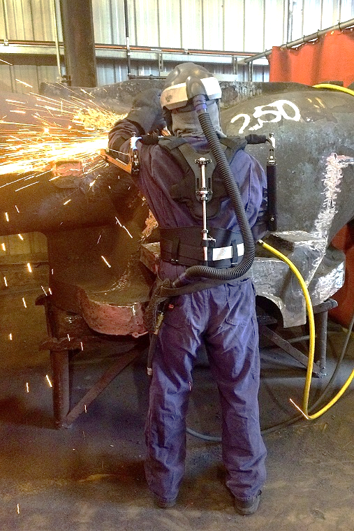 Person using a wearable exoskeleton operating heavy machinery