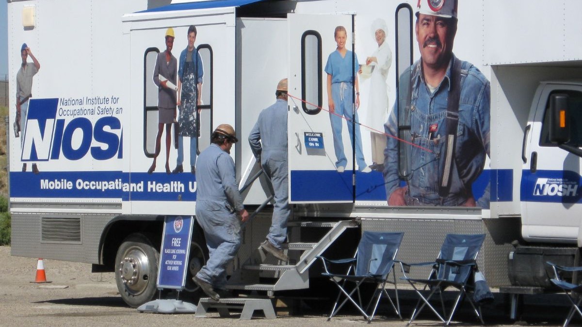 Two coal miners enter the NIOSH mobile screening unit.