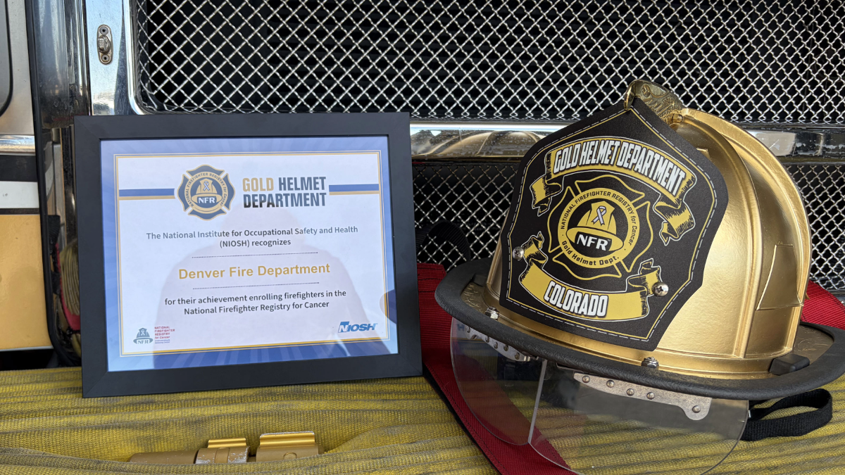 Framed certificate next to a gold firefighter helmet with "Gold Helmet Department Colorado" written on it.