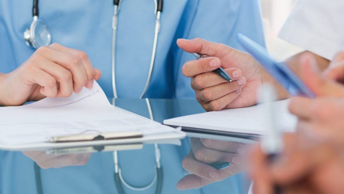 Medical professionals in scrubs looking at documents