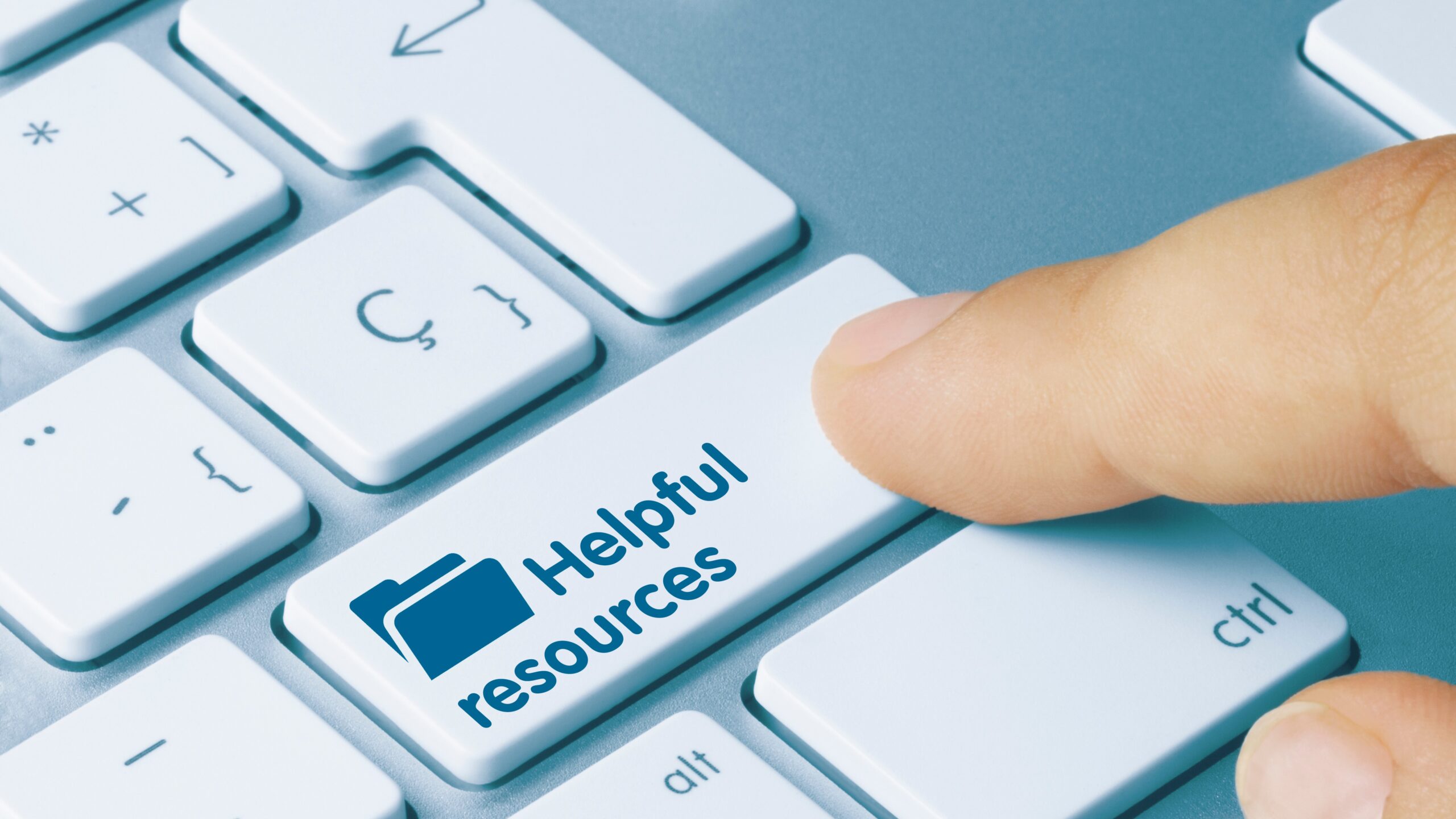 Closeup of a finger pressing a laptop keyboard key that says "Helpful resources" with a folder icon on it.