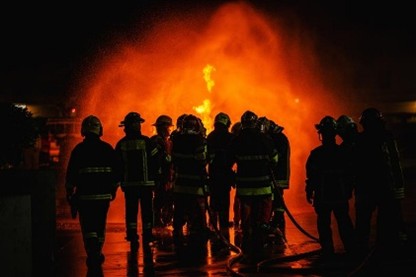 firefighters standing before a blaze
