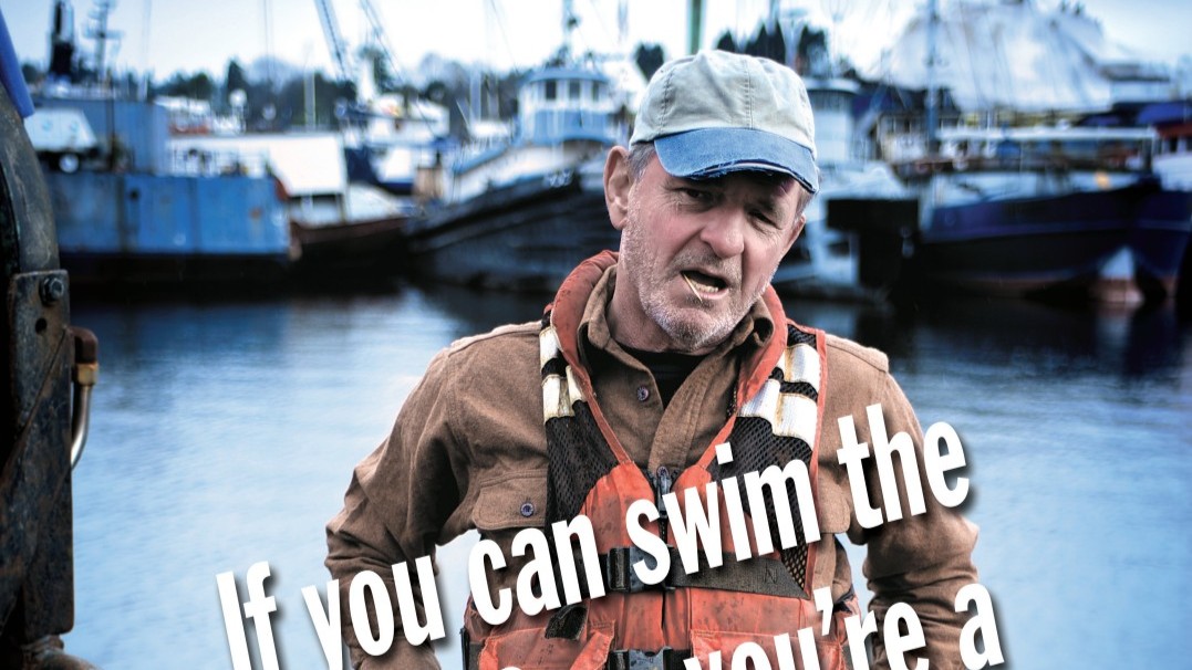 Commercial fisherman standing in a marina wearing a personal flotation device