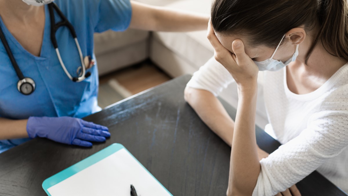 A female patient discusses her symptoms with her healthcare provider.