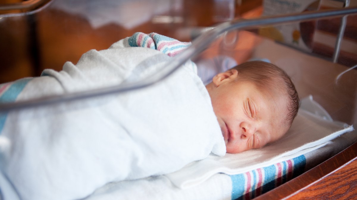 An infant sleeps in a hospital nursery.