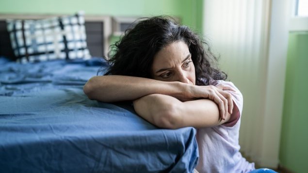 Polysubstance-Page-Thumb Woman with her head on the corner of a bed.