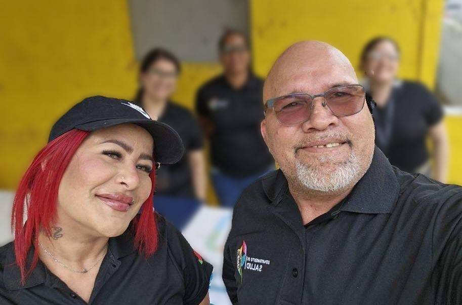 A bald man with glasses and a woman with a cap and red hair from Puerto Rico's Navigator Program smile in a selfie.